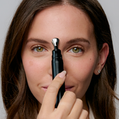 A model holding the Wrinkle Pen's metal tip between her brows.